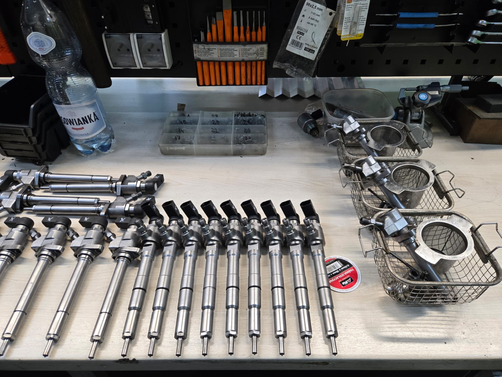 Rozłożone wtryskiwacze i części na stole serwisowym